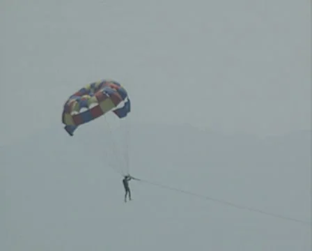 Person parasailing going down into water then up again Vídeos de archivo 8299504