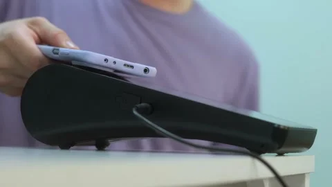 Person paying using smartphone touching card reader in shop Stock Footage 245580695