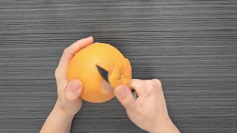 A person peeling a grapefruit with a knife Stock Footage 342030031