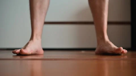 A person performs a kettlebell exercise at home on a wooden floor. This activity Stock Footage 339096004