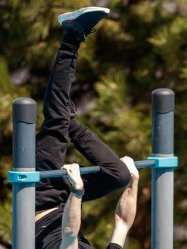 Person performs pull-up outdoors Stock Photos