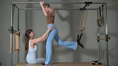A person performs stretching exercises with the help of an instructor in a Видео 344374954
