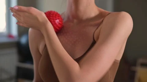 A person performs upper body exercises with a massage ball in a room designed Vídeos de archivo 344374694