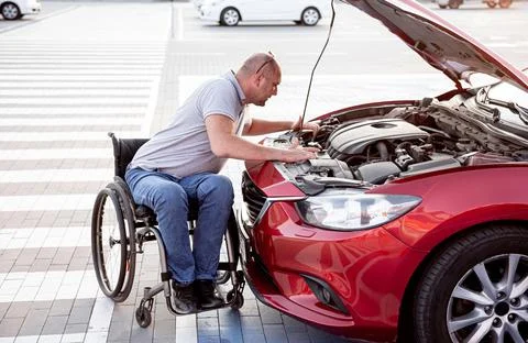 Person with a physical disability check engine his car at parking Stock Photos