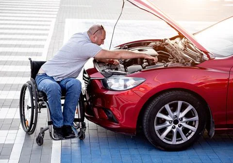 Person with a physical disability check engine his car at parking Stock Photos