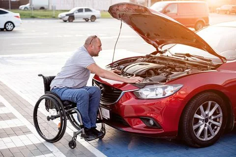 Person with a physical disability check engine his car at parking Foto stock