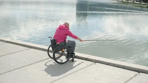 Person With A Physical Disability Who Uses Wheelchair Fishing From