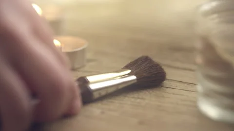 Person picking up brushes on table with candles Stock Footage 275455258