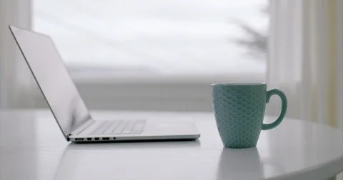 Person picking up a coffee cup from a computer desk. Vidéo 88370268
