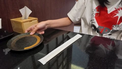 Person Picking Up Empty Plate at Asian Restaurant Table Stock Footage 340863634