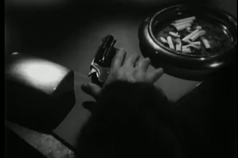 Person picking up gun from table Stock Footage 25195480