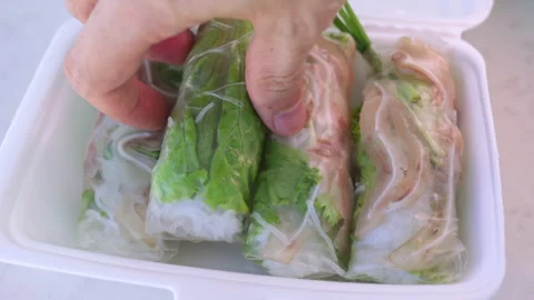 Person picking up vietnamese fresh spring roll from takeout container Video stock 337360306