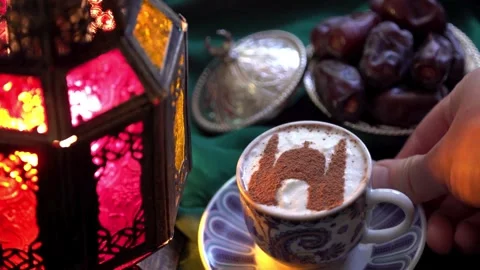Person placing a coffee cup with mosque silhouette art during Ramadan Stock Footage 334137205