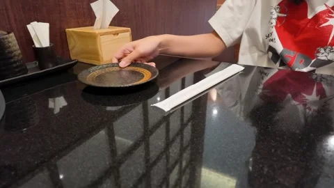 Person Placing Empty Plate on Table in Asian Restaurant Stock Footage 340378486