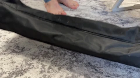 Person placing folded camping tent bag on floor preparing outdoor equipment Stock Footage 336976751