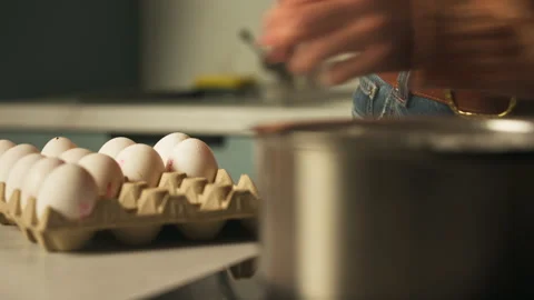 Person Placing Fresh Eggs Using Spoon Into Pot With Boiling Water In The Vídeo Stock 331172034