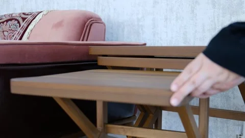 Person Placing a Side Table into Nested Tables Next to a Sofa – Living Room Video stock 302687905