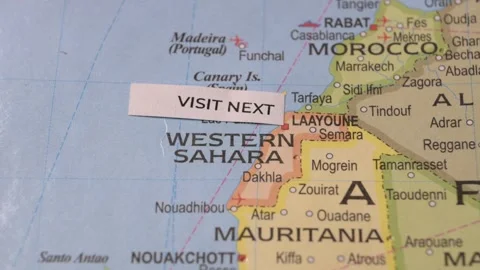 Person placing Visit Next label on map over Western Sahara travel concept Stock Footage 346743863