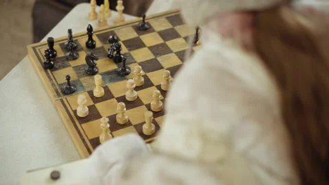 Person Playing Chess with Hand Hovering Over Wooden Board Video stock 329464087