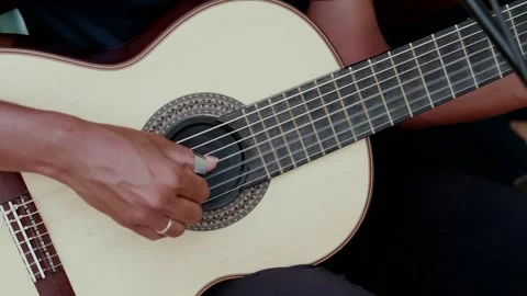 Person playing classical guitar with fingerpick creating music Stock Footage 345855251