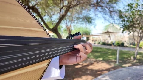 A person playing an oud, a prominent stringed instrument in Middle Eastern music Vídeos de archivo 322666940
