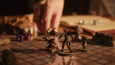 A person playing a tabletop roleplaying game with miniatures and dice Stock Footage 276479343