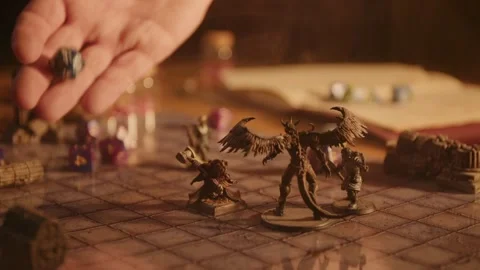 A person playing a tabletop roleplaying game with miniatures and dice Stock Footage 276479346