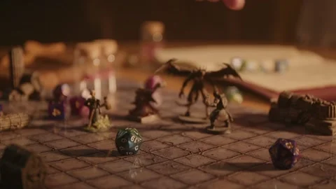 A person playing a tabletop roleplaying game with miniatures and dice Stock Footage 276479668