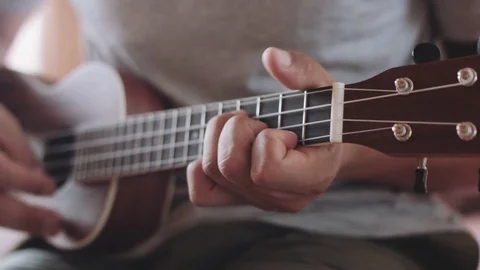 Person playing on ukulele guitar inside Stock Footage 79464614