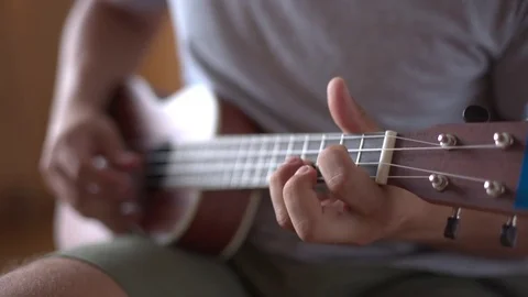 Person playing on ukulele guitar inside Vidéo 79482755
