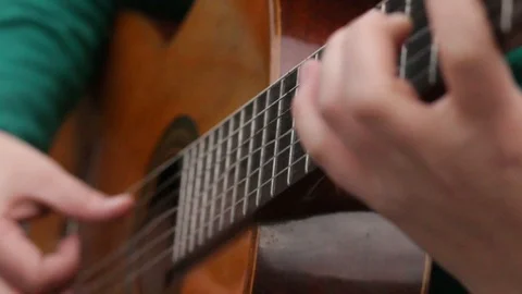  person plays the guitar and the strings vibrate and move Stock Footage 123799710