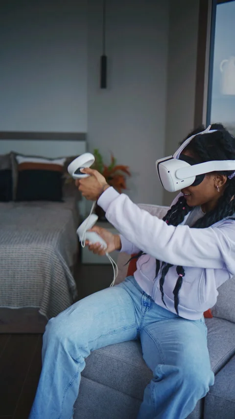 Person plays virtual reality game in living room during daytime while wearing VR Stock Footage 339035353