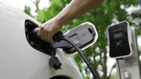 Person plug cable in electric car port at charger station Stock Footage 344462430
