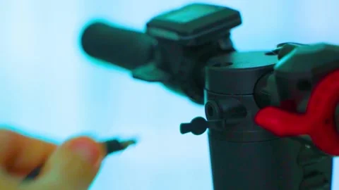 Person plugging charging cable into electric scooter port close up shot Stock-Footage 342905649