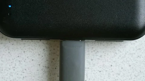 Person plugging a usb c cable into a black power bank device Video stock 337828284