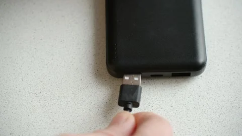Person plugging a usb cable into a black power bank charger Stock Footage 337828251