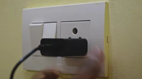 Person plugs an adopter into a socket and turns on the switch 4k Vídeo Stock 289400508