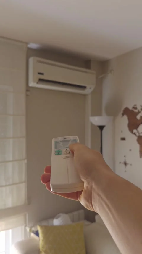 Person pointing remote control at air conditioner Stock Footage 341038349