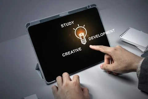A person is pointing at a tablet with the words study, creative, development Stock Illustration