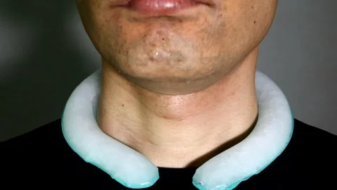 A person posing with an ice pack wrapped around their neck. Stock Footage 334633599