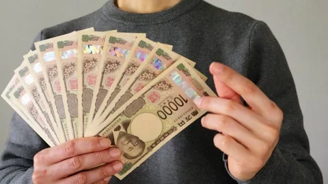 Person posing with a large number of 10,000 yen bills Video stock 324546873