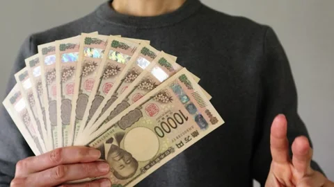 A person posing with a large number of 10,000 yen bills Stock Footage 324546875