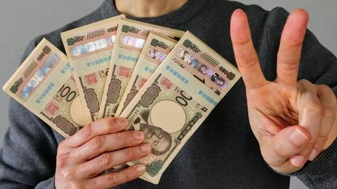 A person posing with a stack of banknotes. Stock Photos
