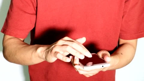 A person posing while operating a smartphone. Stockbeeldmateriaal 334697932