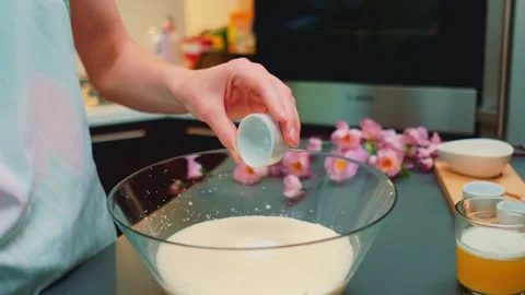 Person pouring powdered sugar into egg foam in kitchen 库存影片 342866554