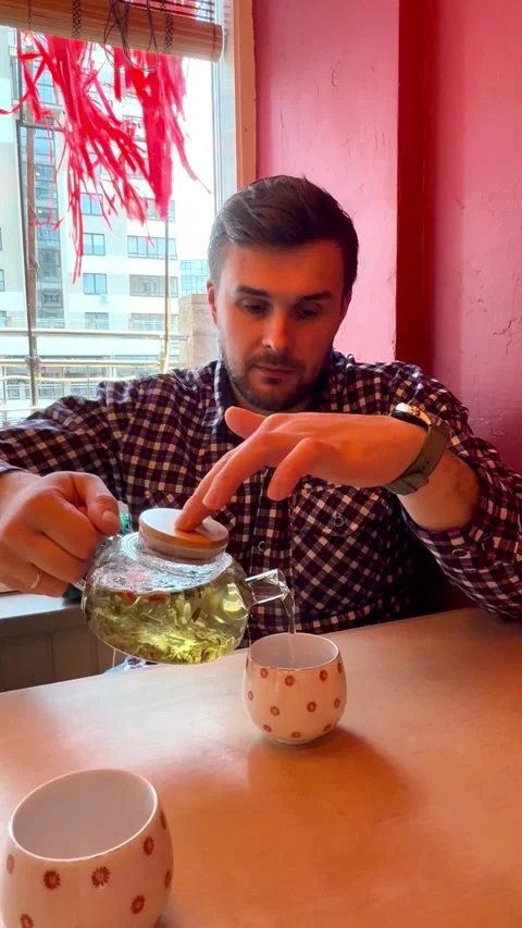 Person pouring tea at table, cozy lifestyle moment with warm drink and relaxed a Stock Footage 334793852