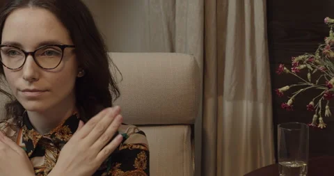 A person practicing the butterfly hug while sitting in an armchair at home. Stock Footage 279258395