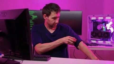 Person prepares for coding task. Individual adjusts workspace with colorful Stock-Footage 347875109
