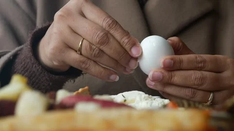 Person prepares egg at breakfast table in a home Stock Footage 339755747