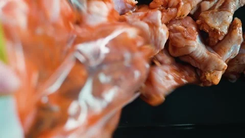A person prepares marinated chicken by applying spices in a kitchen. The process Stock-Footage 338290066